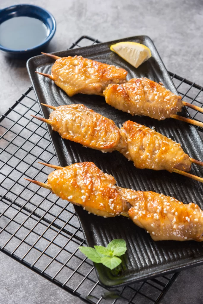 Grilled Chicken Skewers Sesame Garnish Golden Brown Plated