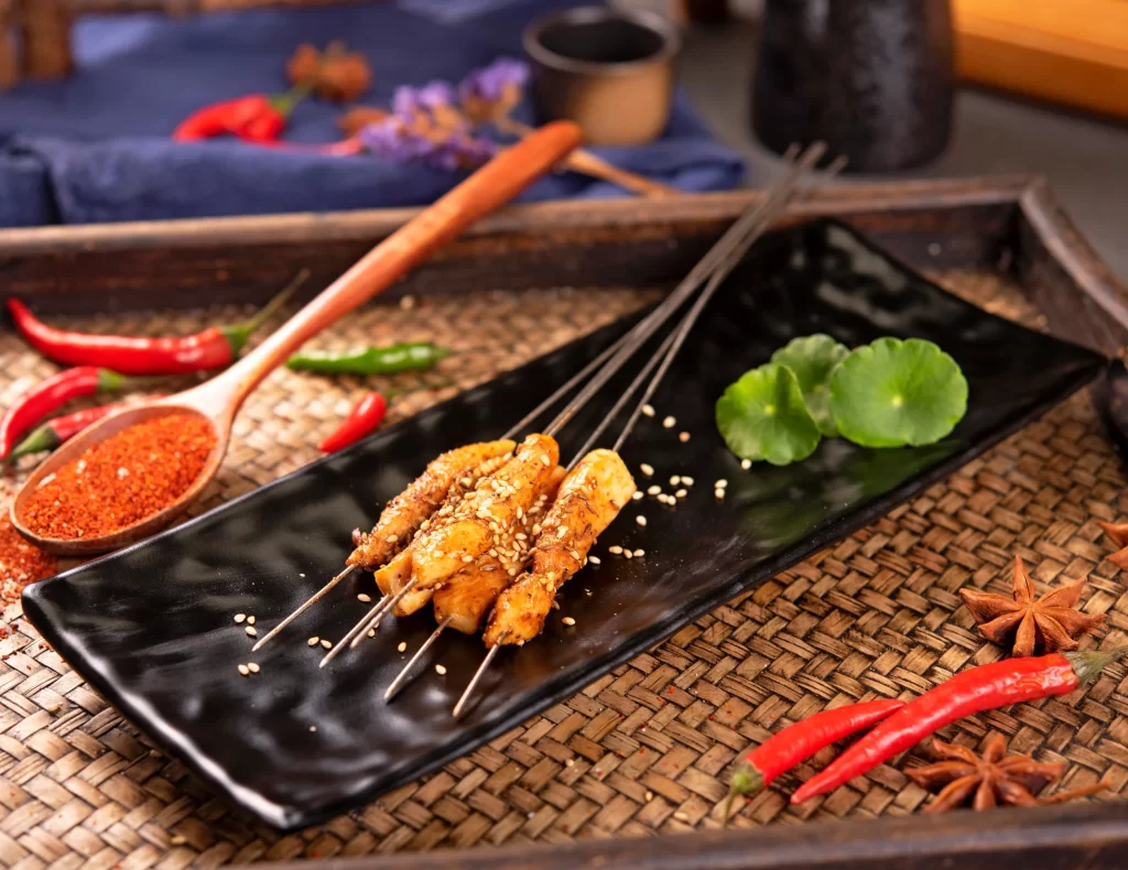Grilled Chicken Skewers Sesame Seeds Green Garnish Black Plate