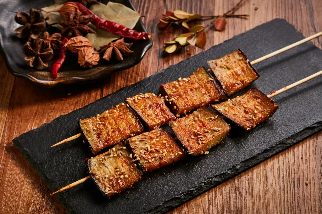 Grilled Eggplant Skewers Spicy Sauce Sesame Garnish Slate Plate