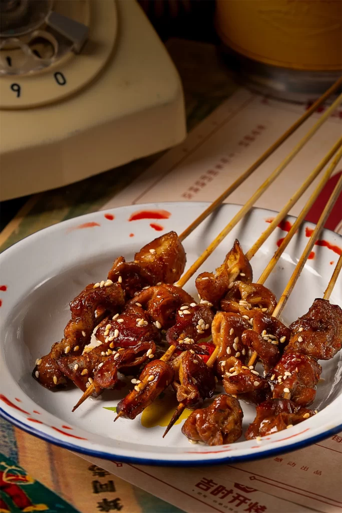 Grilled Pork Skewers Sesame Garnish Red Sauce Plated