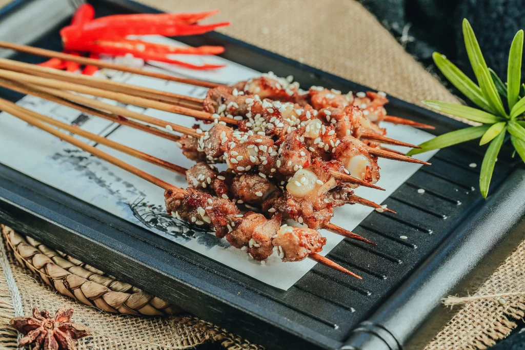 Grilled Pork Skewers Sesame Seeds Charred Crust Plated