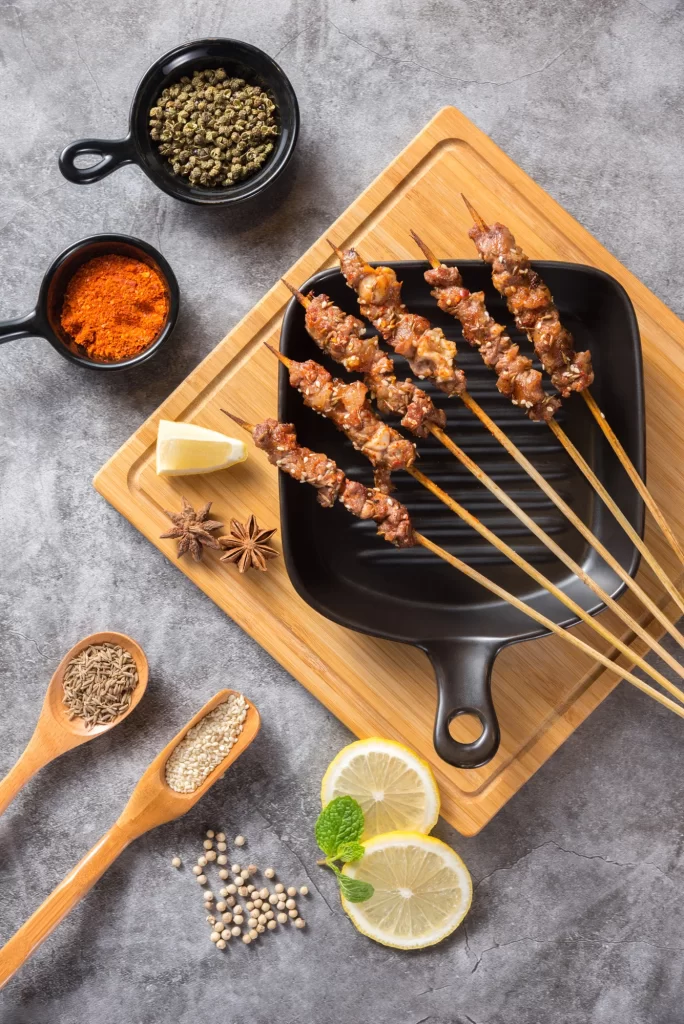 Grilled Pork Skewers Spices Lemon Garnish Black Plate