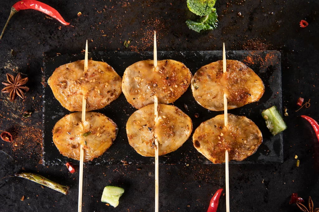 Grilled Pork Skewers Spicy Sauce Charred Edges Garnish