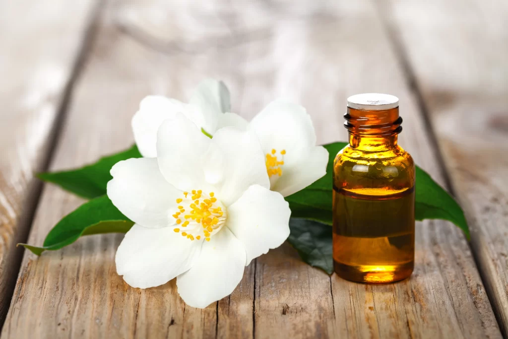 Jasmine White Petals Yellow Center Green Leaves Brown Bottle