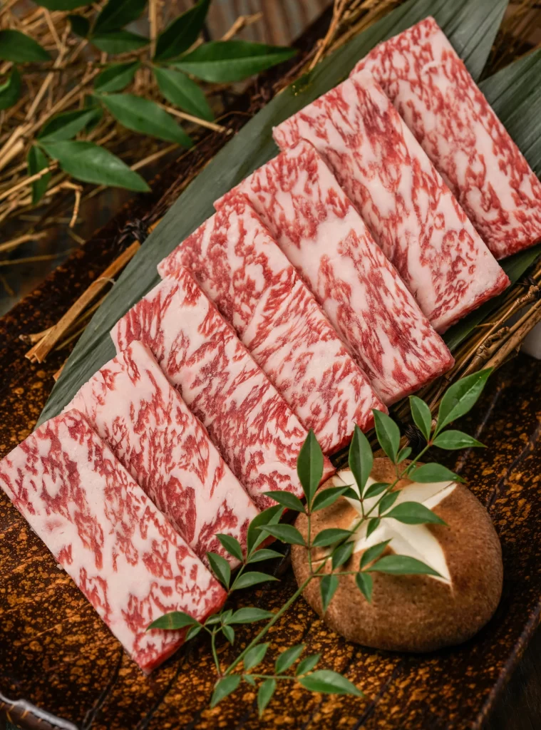 Kobe Beef Ribeye Marbled Red White Leafy Garnish Dark Plate