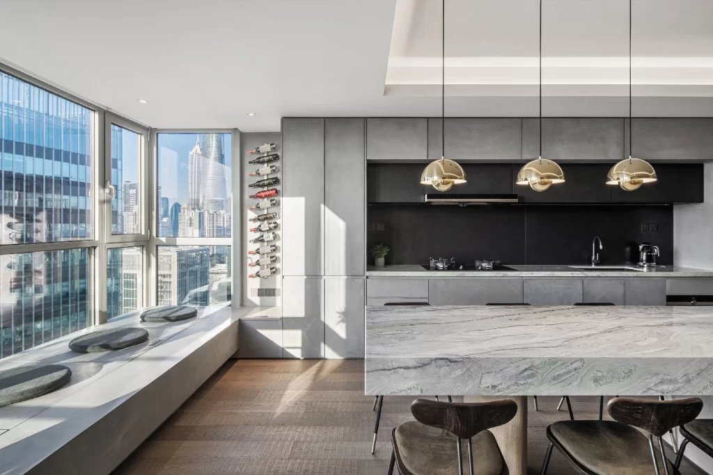 Modern Kitchen Dining Area Grey Marble Black Cabinetry Gold Lighting