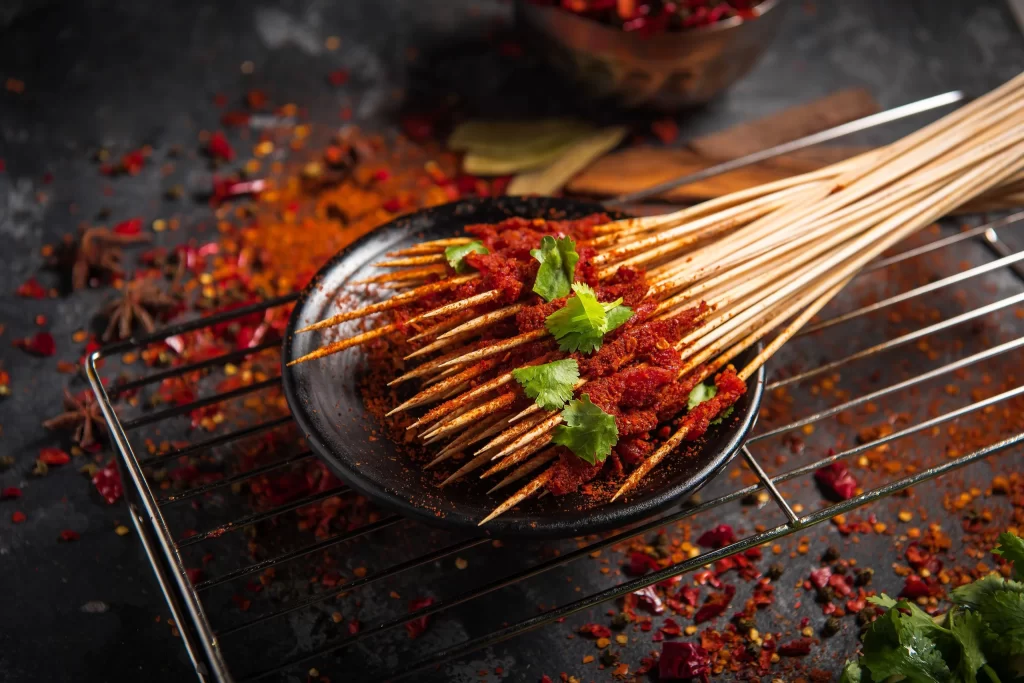 Spicy Beef Skewers Cilantro Garnish Red Chili Powder Black Plate