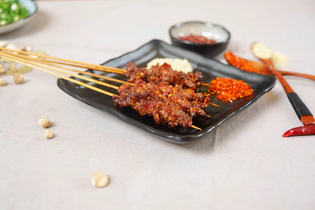Spicy Beef Skewers Red Chili Garnish Black Plate