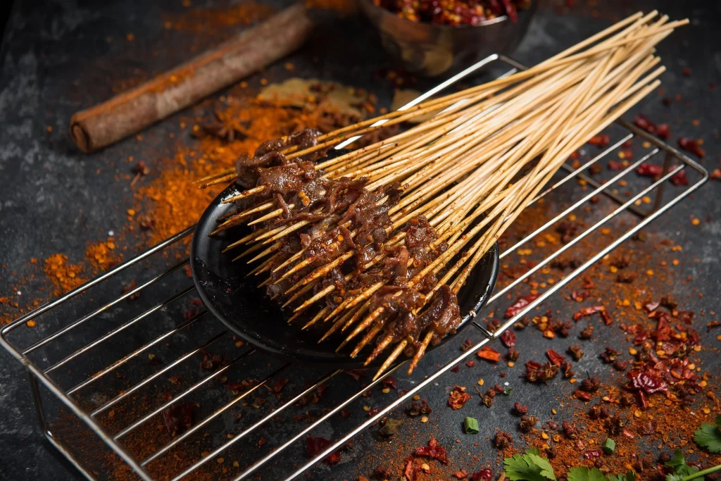 Spicy Beef Skewers Red Chili Garnish Dark Plate