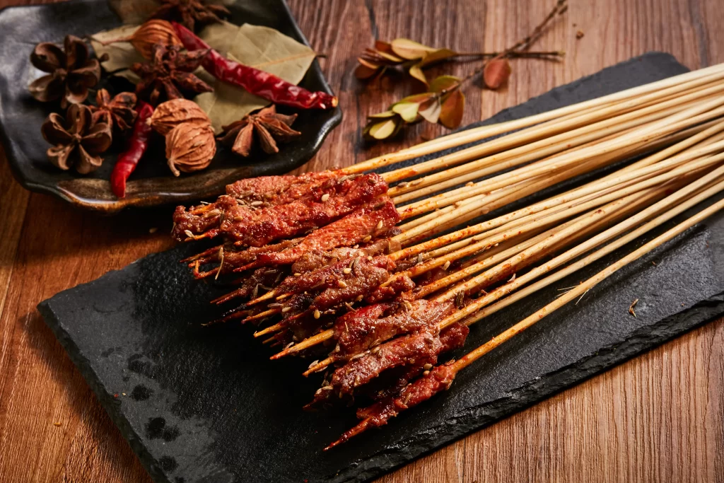 Spicy Beef Skewers Red Sauce Charred Edges Black Slate