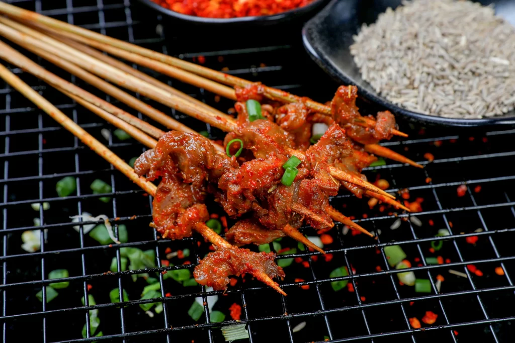 Spicy Beef Skewers Red Sauce Green Onion Garnish