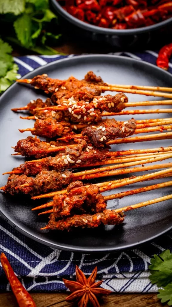 Spicy Beef Skewers Sesame Garnish Black Plate