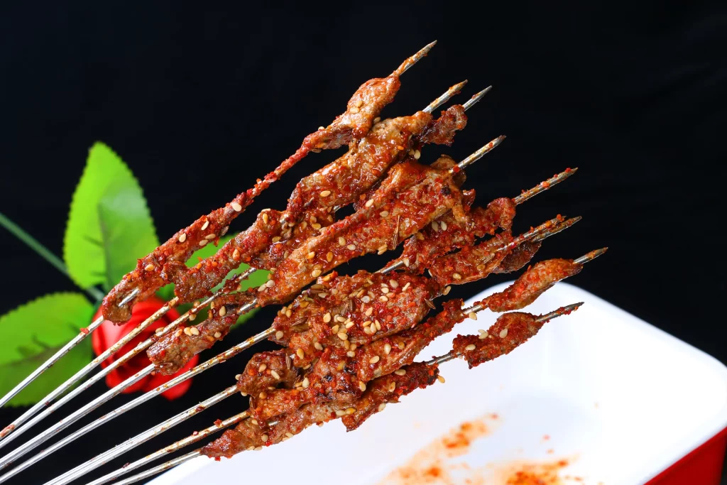 Spicy Beef Skewers Sesame Seeds Red Chili Powder White Plate