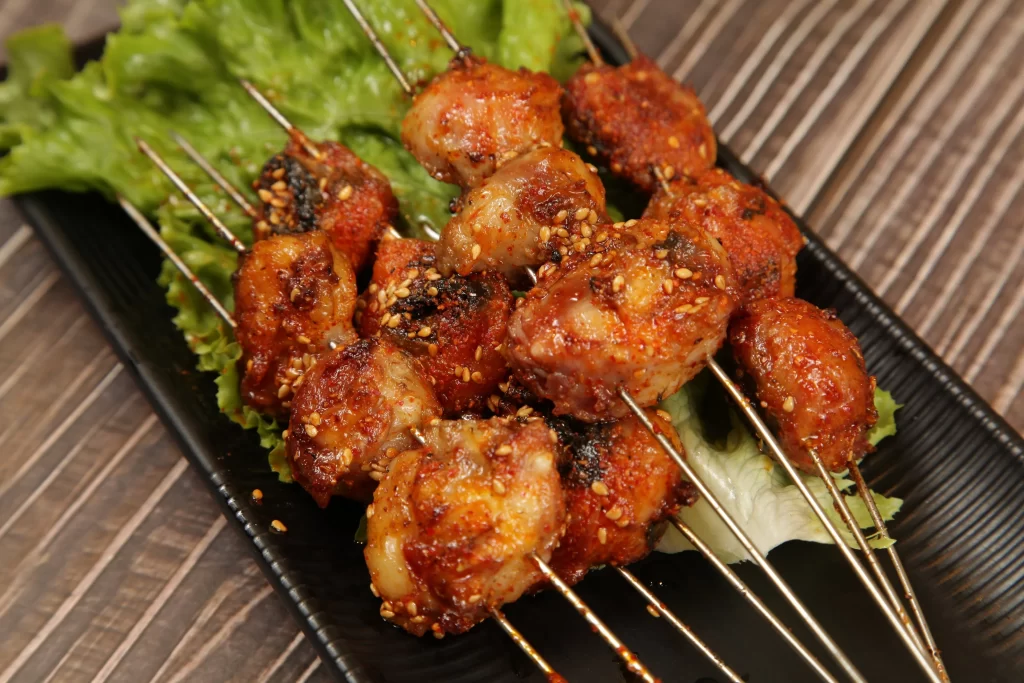 Spicy Chicken Skewers Sesame Garnish Green Lettuce Plated