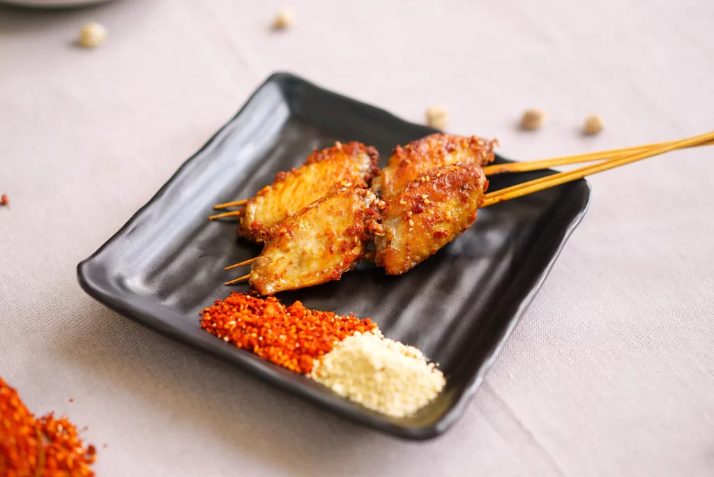 Spicy Chicken Wings Skewers Red Pepper Flakes Black Plate