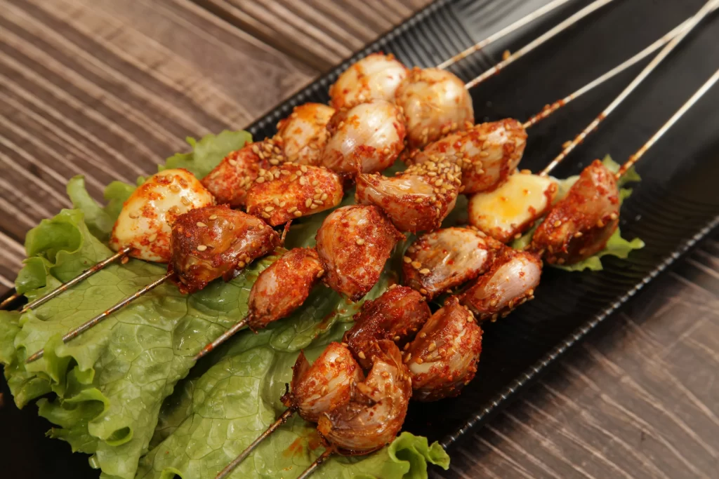 Spicy Garlic Skewers Sesame Garnish Fresh Lettuce Plated
