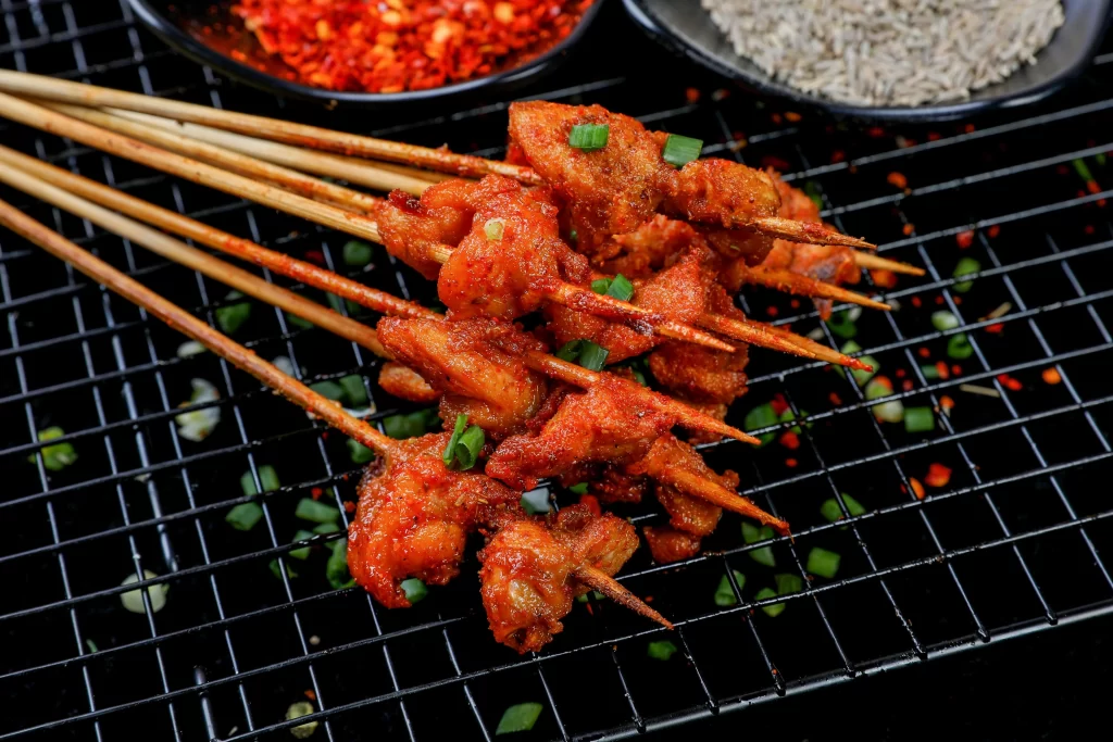 Spicy Grilled Chicken Skewers Red Sauce Green Onion Garnish