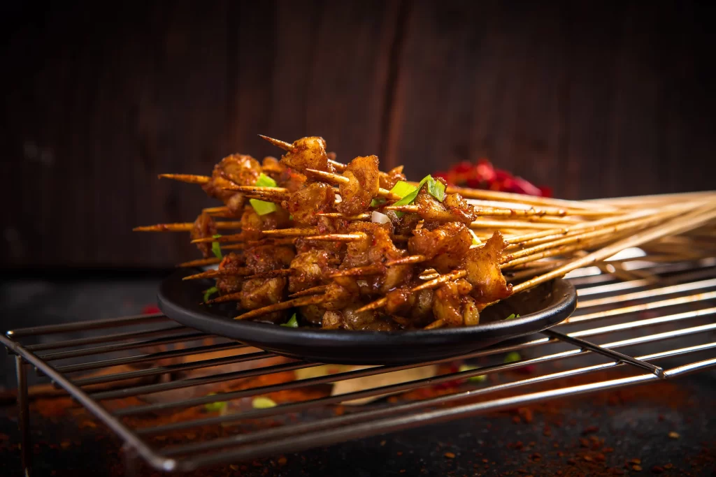 Spicy Grilled Chicken Skewers with Charred Edges and Green Onion Garnish