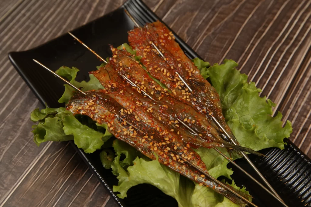 Spicy Grilled Fish Skewers Sesame Seeds Green Lettuce Plated