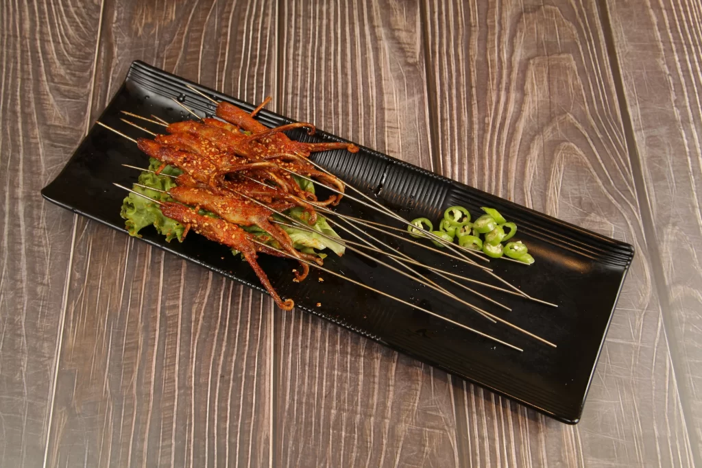 Spicy Grilled Octopus Skewers Green Chili Garnish Black Plate