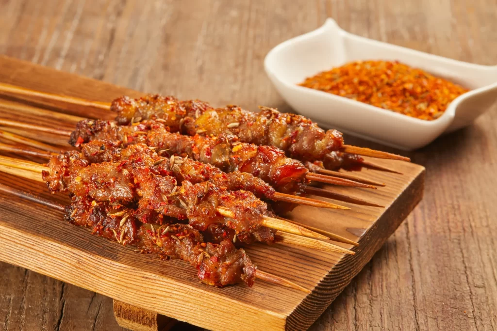 Spicy Lamb Skewers Charred Crust Red Pepper Garnish
