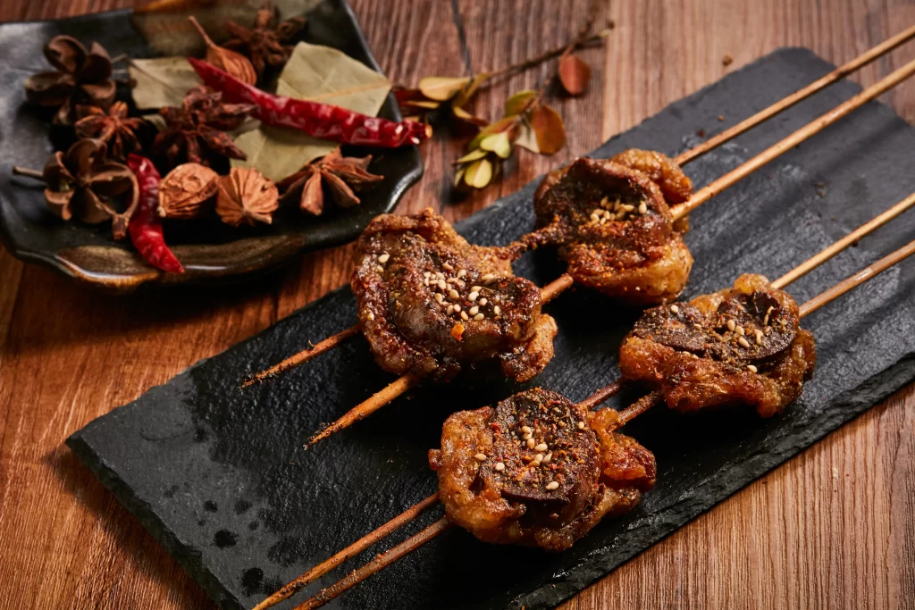 Spicy Lamb Skewers Charred Crust Sesame Garnish Slate Plate