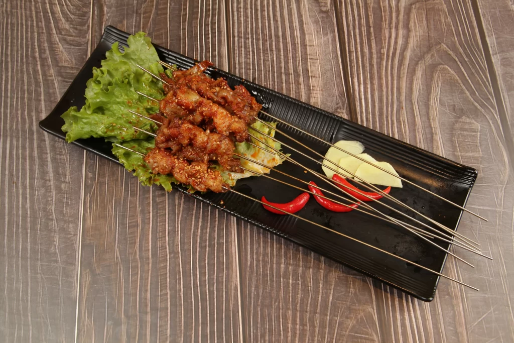 Spicy Pork Skewers Charred Crust Fresh Lettuce Garnish