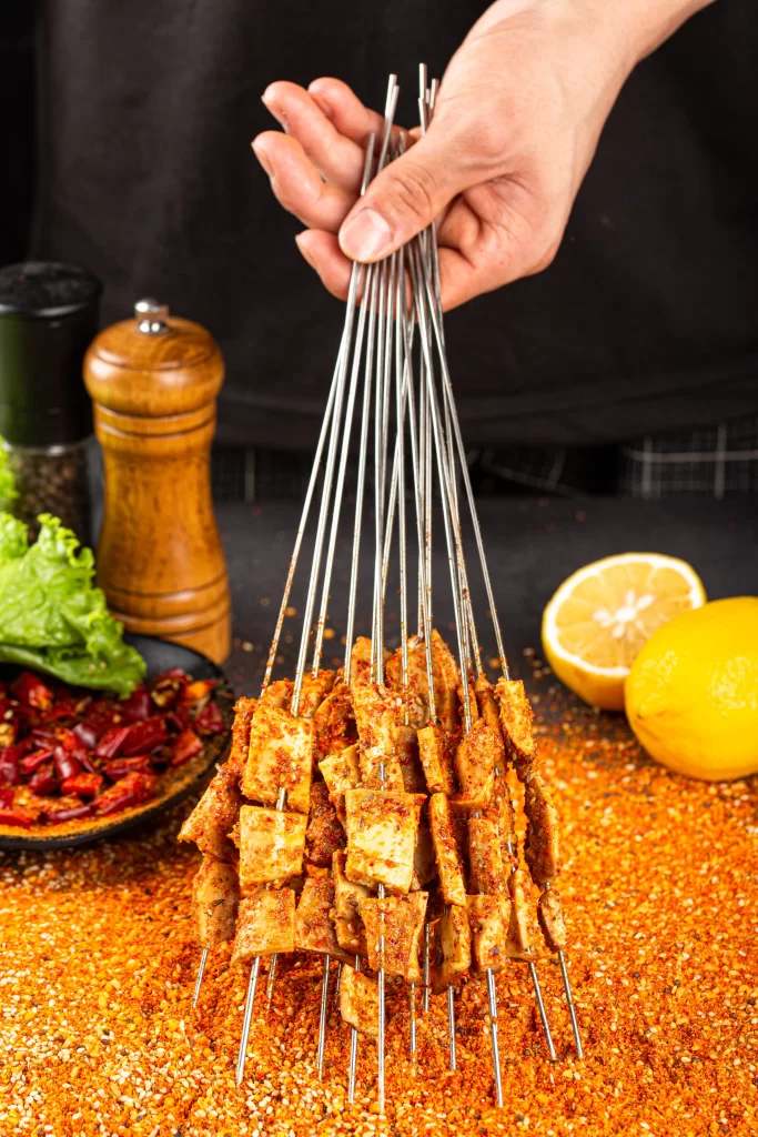 Spicy Pork Skewers Charred Crust Red Pepper Flakes Garnish