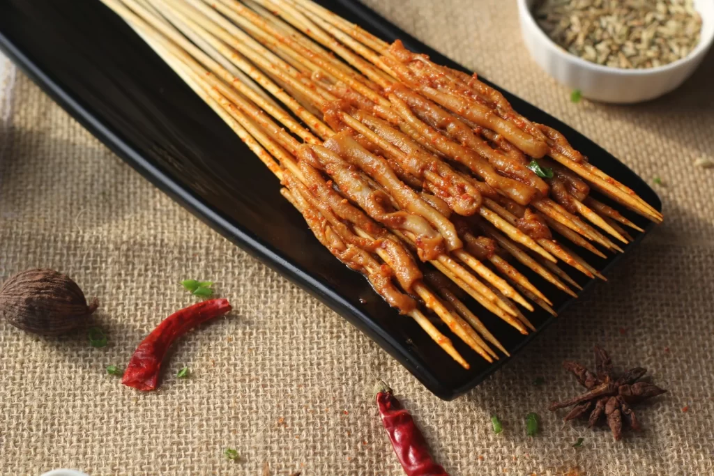 Spicy Pork Skewers Charred Golden Brown Black Plate