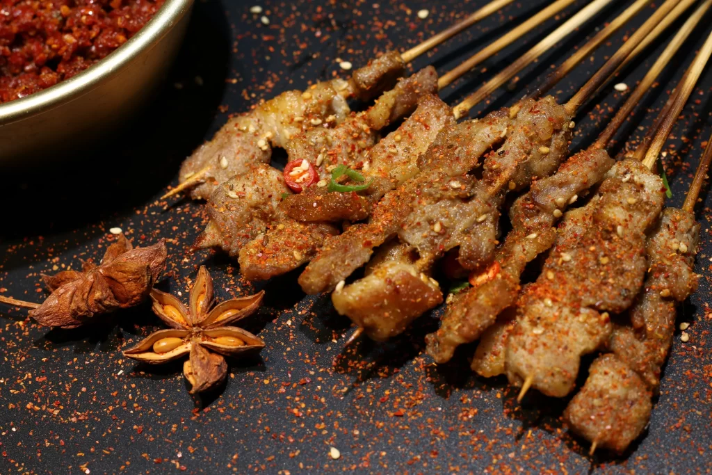 Spicy Pork Skewers Red Chili Flakes Sesame Garnish