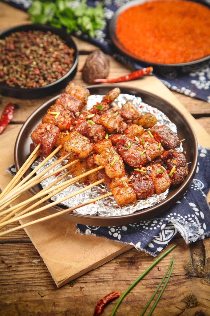 Spicy Pork Skewers Red Chili Garnish Charred Crust Plated