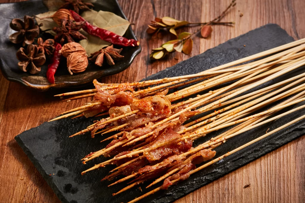Spicy Pork Skewers Red Chili Sauce Charred Edges Black Slate