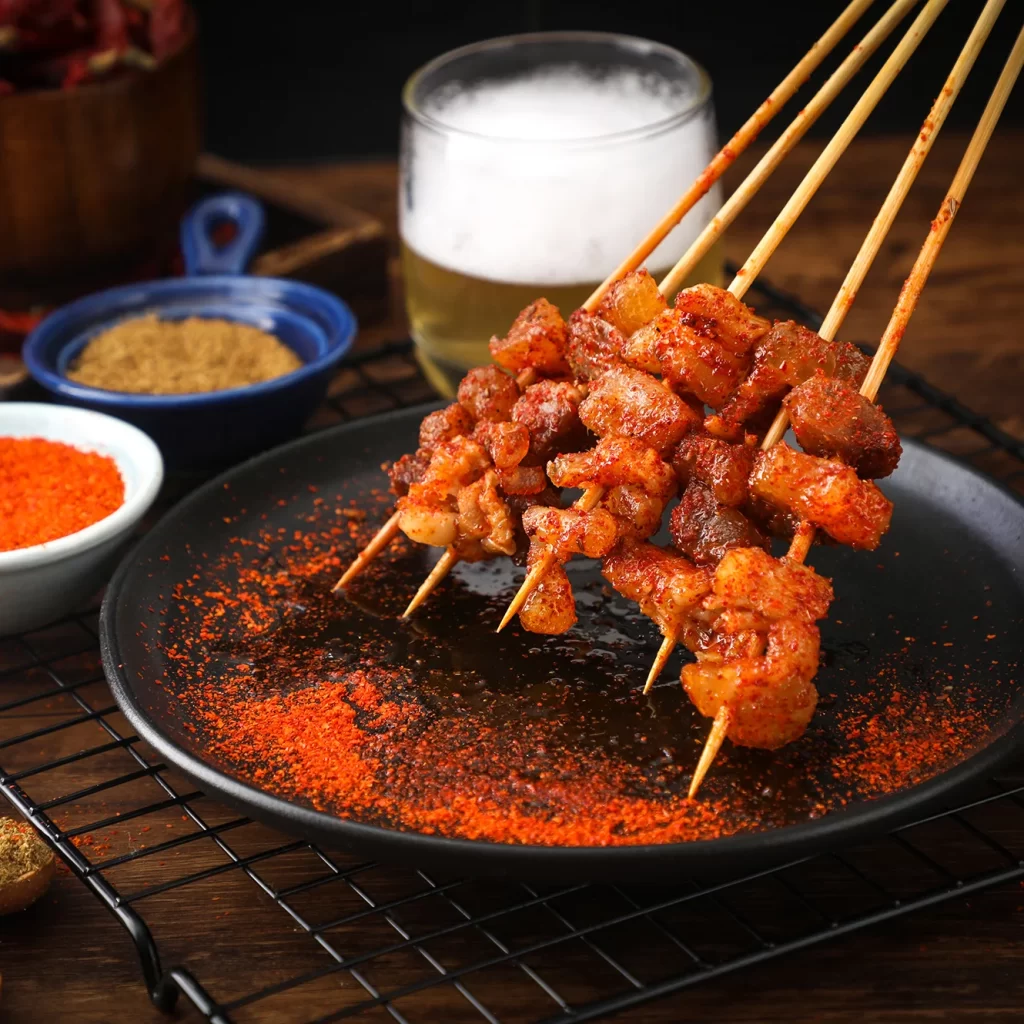 Spicy Pork Skewers Red Pepper Dust Black Plate