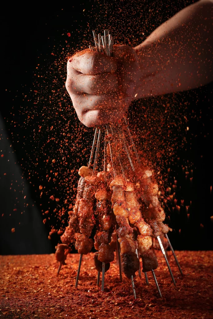 Spicy Pork Skewers Red Pepper Dust Hand Held