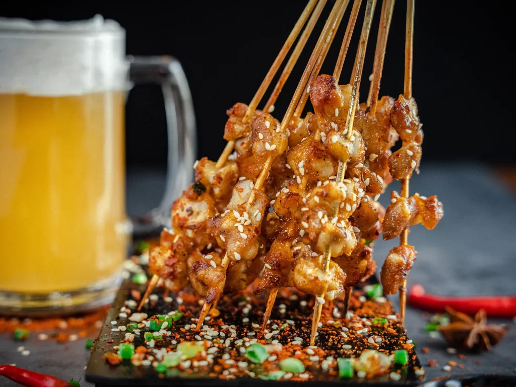 Spicy Pork Skewers Sesame Garnish Golden Brown Charred