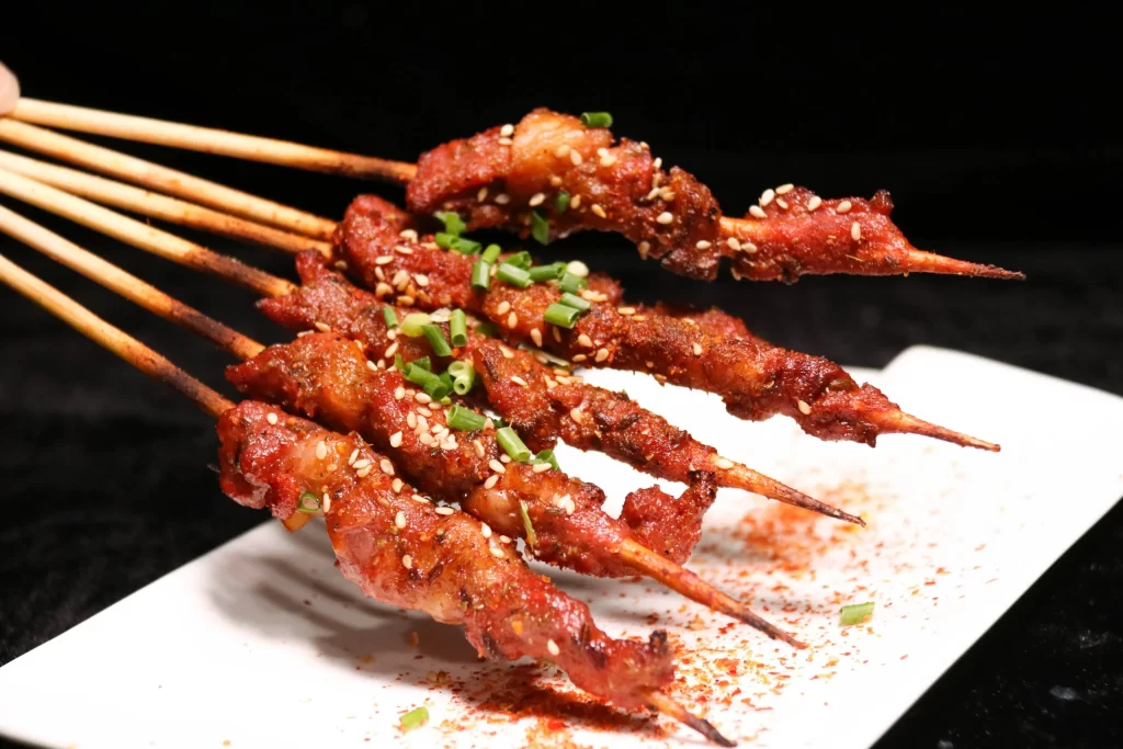 Spicy Pork Skewers Sesame Green Onion White Plate