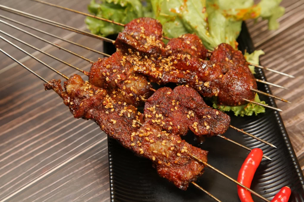 Spicy Pork Skewers Sesame Seeds Crispy Charred Black Plate