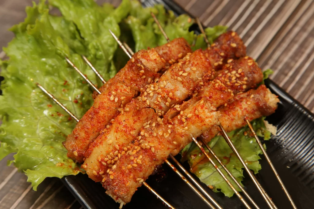 Spicy Pork Skewers Sesame Seeds Crispy Charred Plated