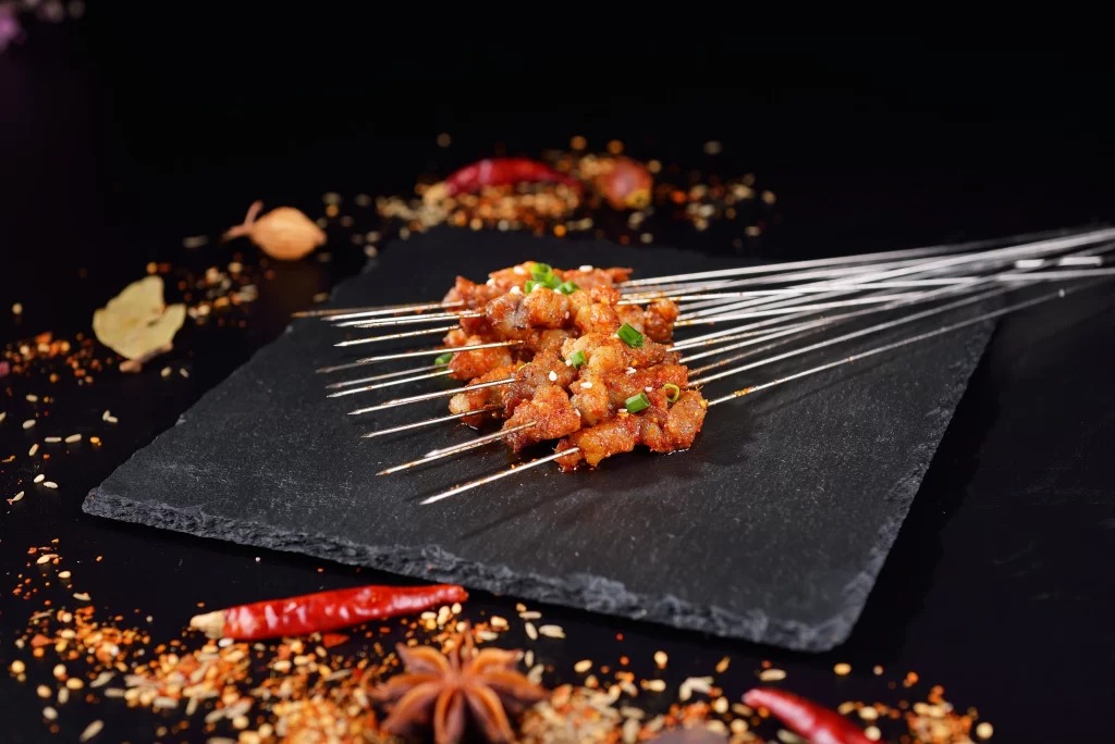Spicy Pork Skewers with Green Onion Garnish Slate Plate