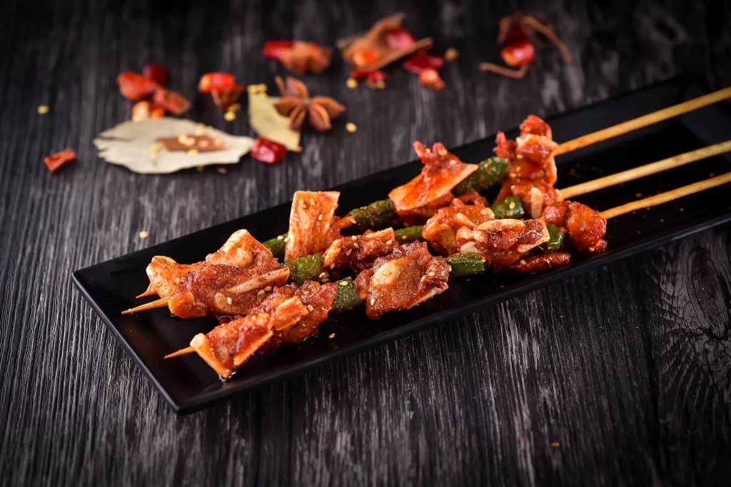 Spicy Pork Skewers with Green Peppers Charred Crust Black Plate