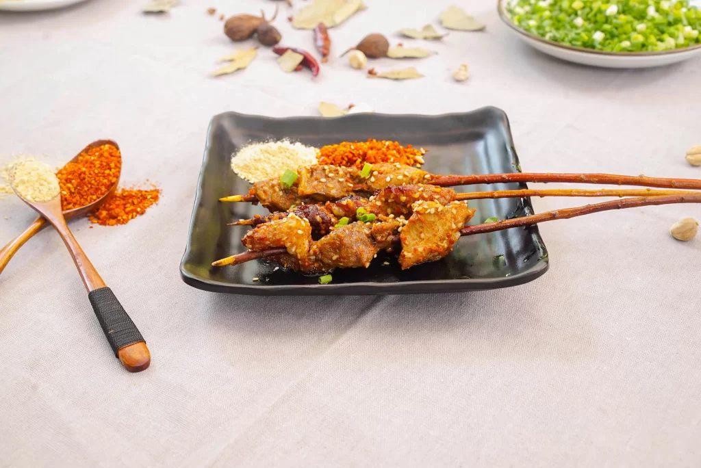 Spicy Pork Skewers with Sesame and Green Onion Garnish