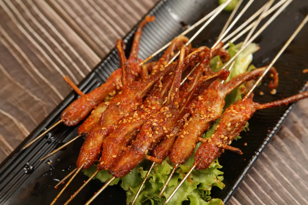 Spicy Pork Skewers with Sesame Garnish Black Plate
