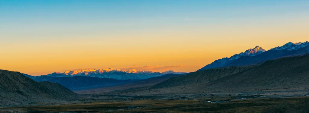 sunset golden amber orange teal blue snow peak ridge valley