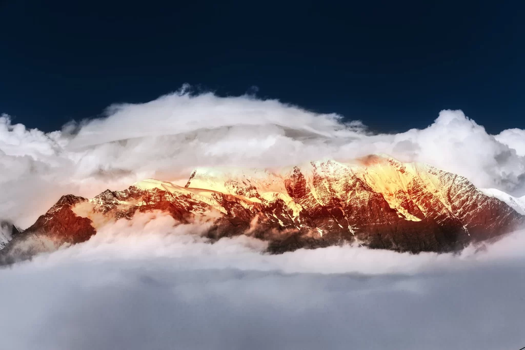 sunset golden amber snow peak ridge clouds aerial