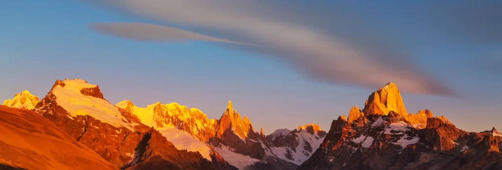 sunset golden amber snow peak ridge valley clouds blue