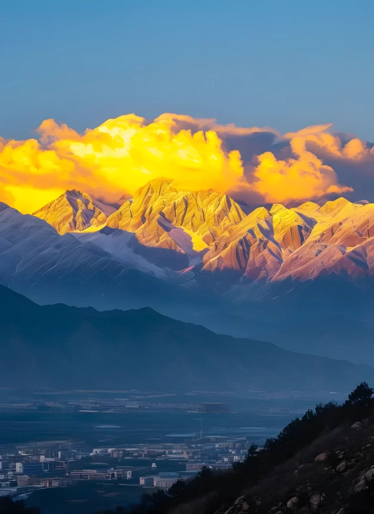 sunset golden clouds snow-capped peaks deep blue sky mountain ridges