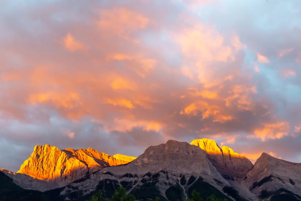 sunset golden-orange clouds mountain peaks rugged terrain dramatic sky
