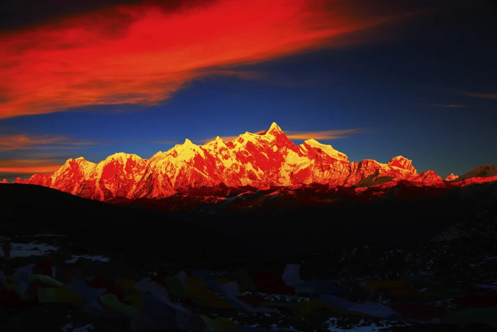 sunset golden red orange blue snow-capped mountain peaks prayer flags