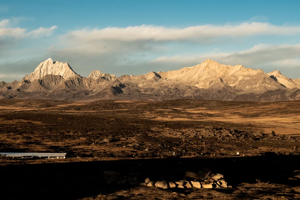 sunset golden rugged peaks vast plains clear sky serene tranquil