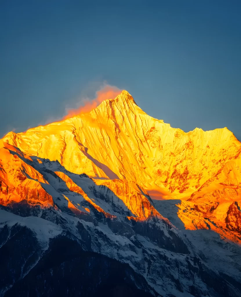 sunset golden snow-capped peaks dramatic shadows clear sky mountain ridges